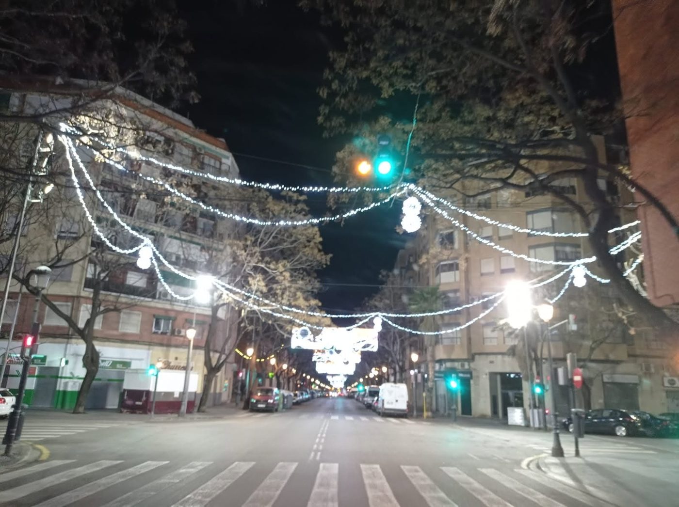 Calle con guirnaldas de luz blanca colgadas entre edificios