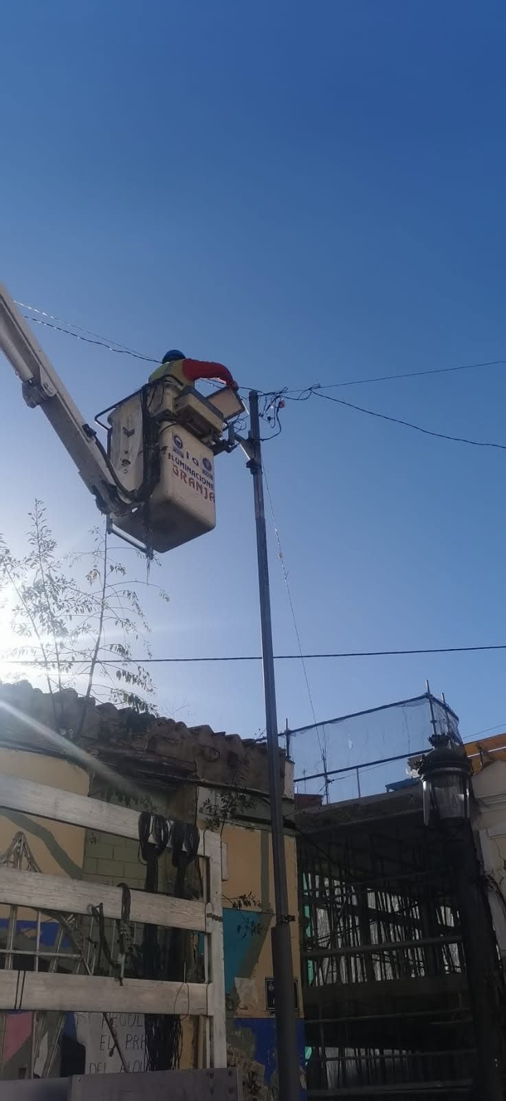 Operario trabajando desde una plataforma elevadora en el montaje de la iluminación